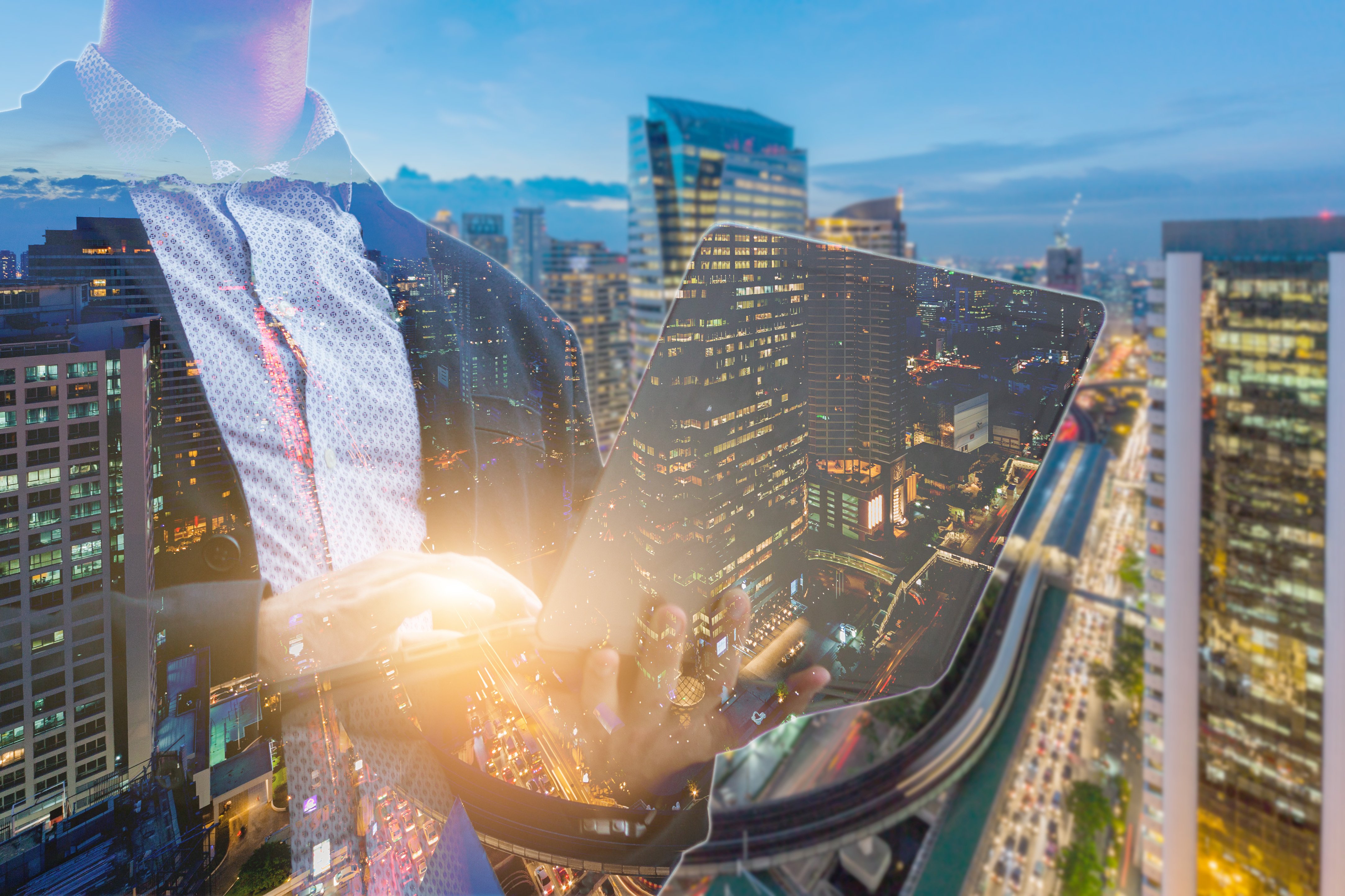 businessman with a laptop and city in the background