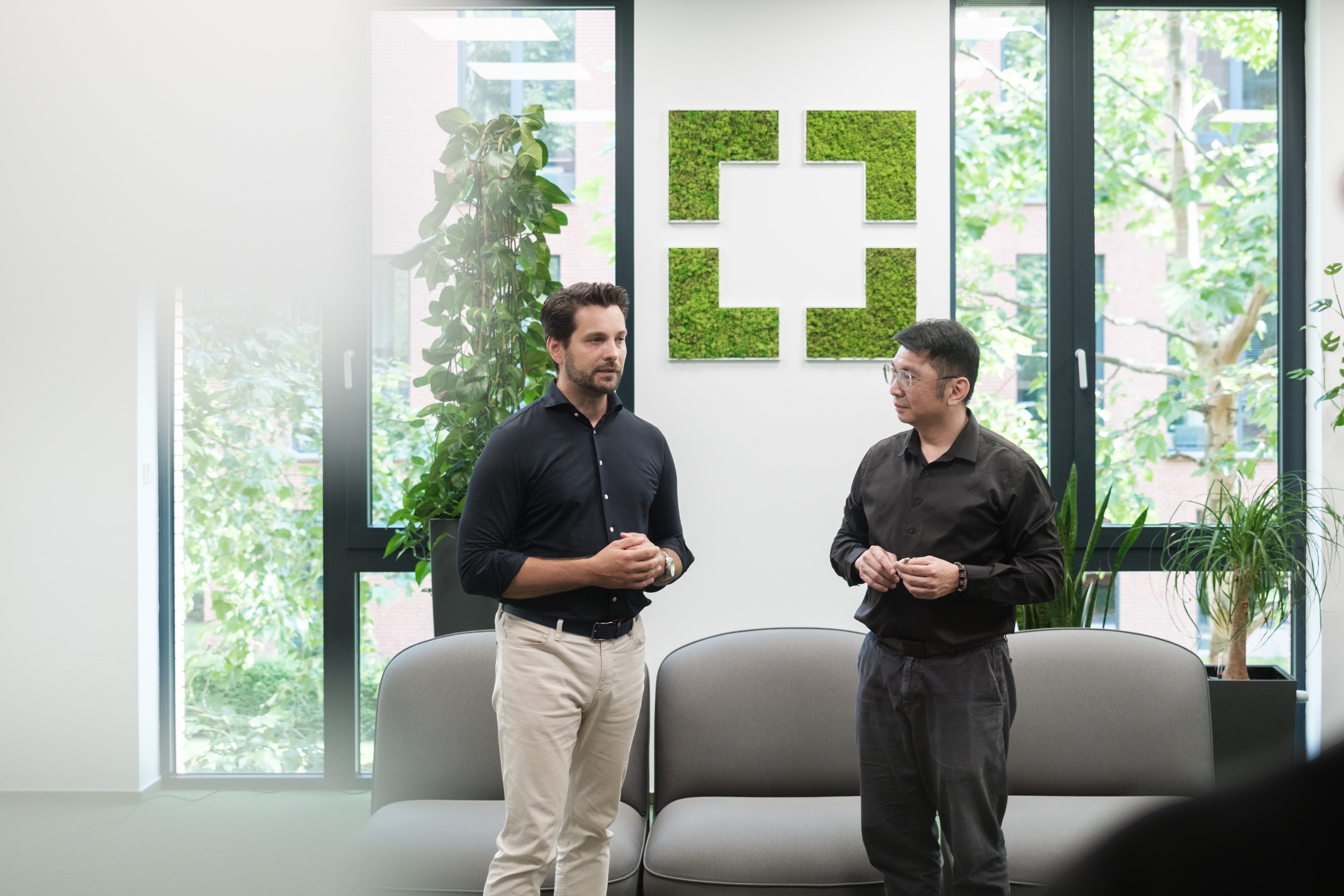 GoodVision CEO and TTS Group's Managing Director discussing partnership in GoodVision’s office with green wall décor.