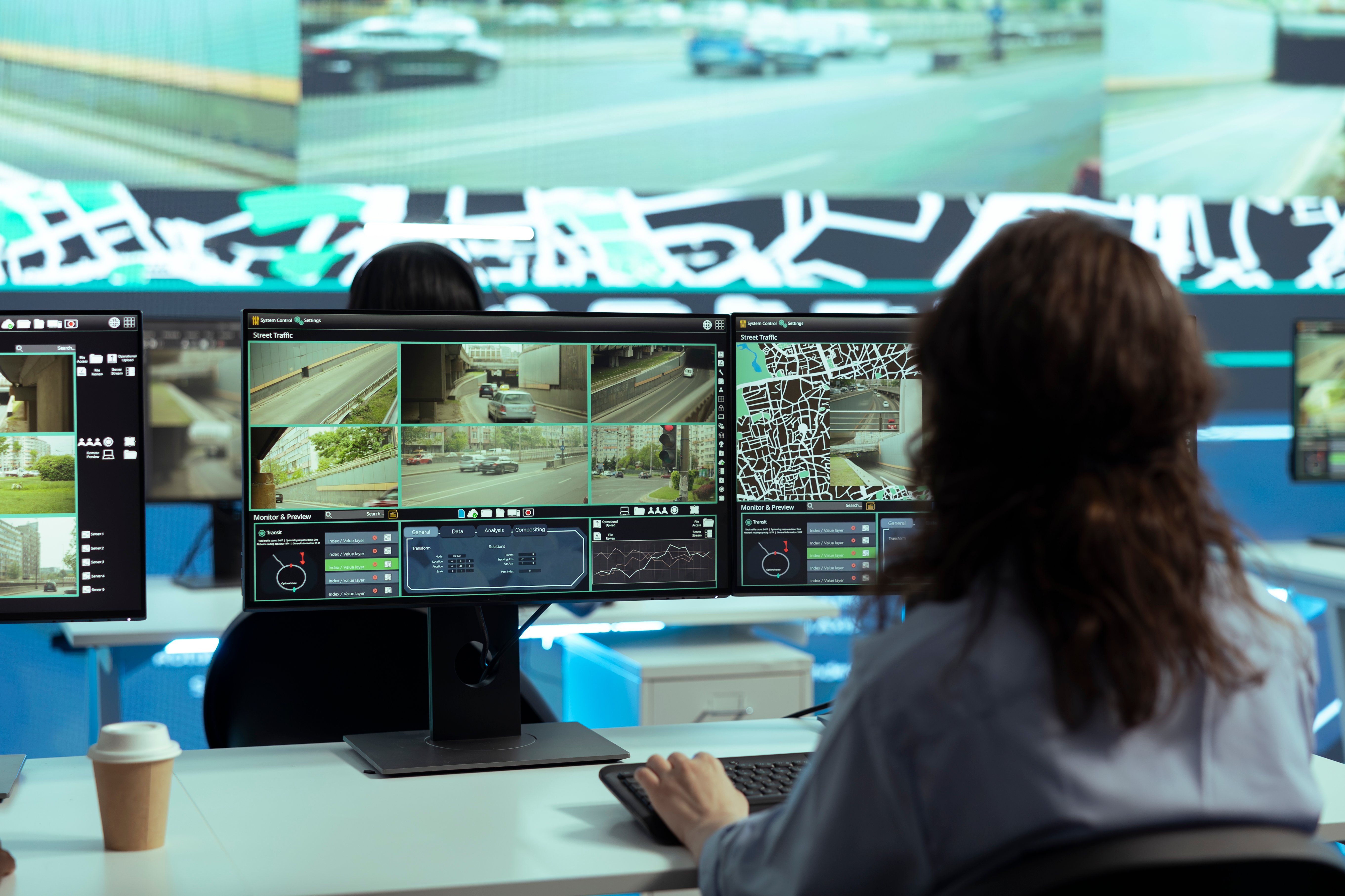 Traffic management center operator reviewing live camera feeds at a network monitoring workstation